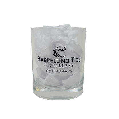 A clear rocks glass with paper inside, featuring the &